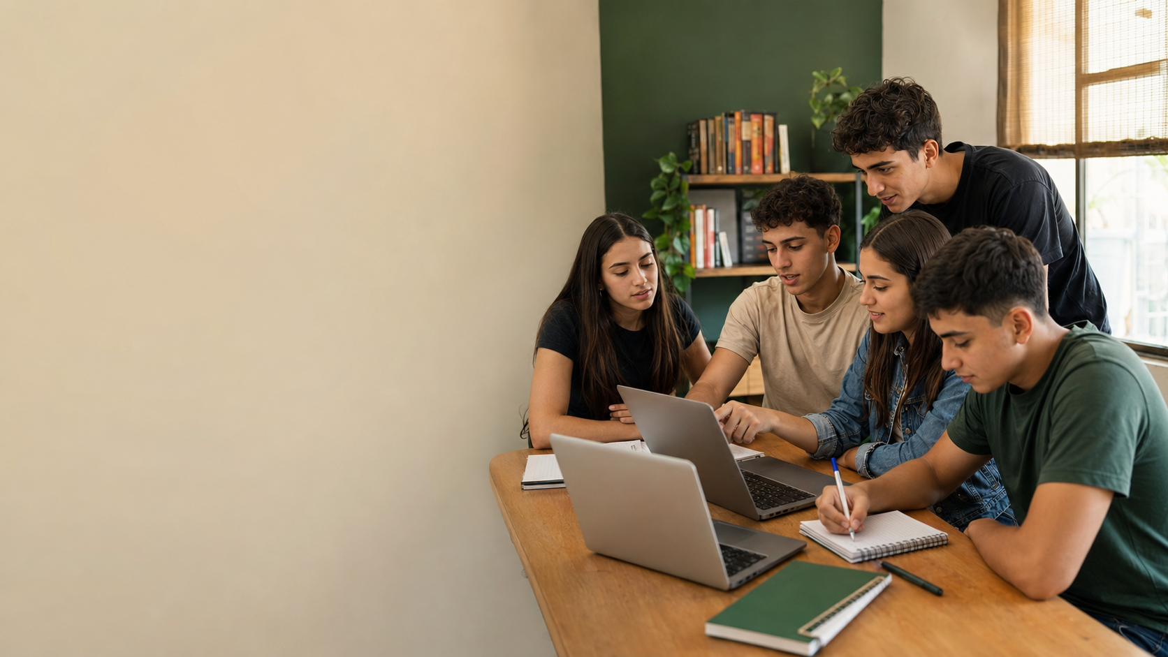 Jóvenes participando en una clase práctica con computadoras y cuadernos